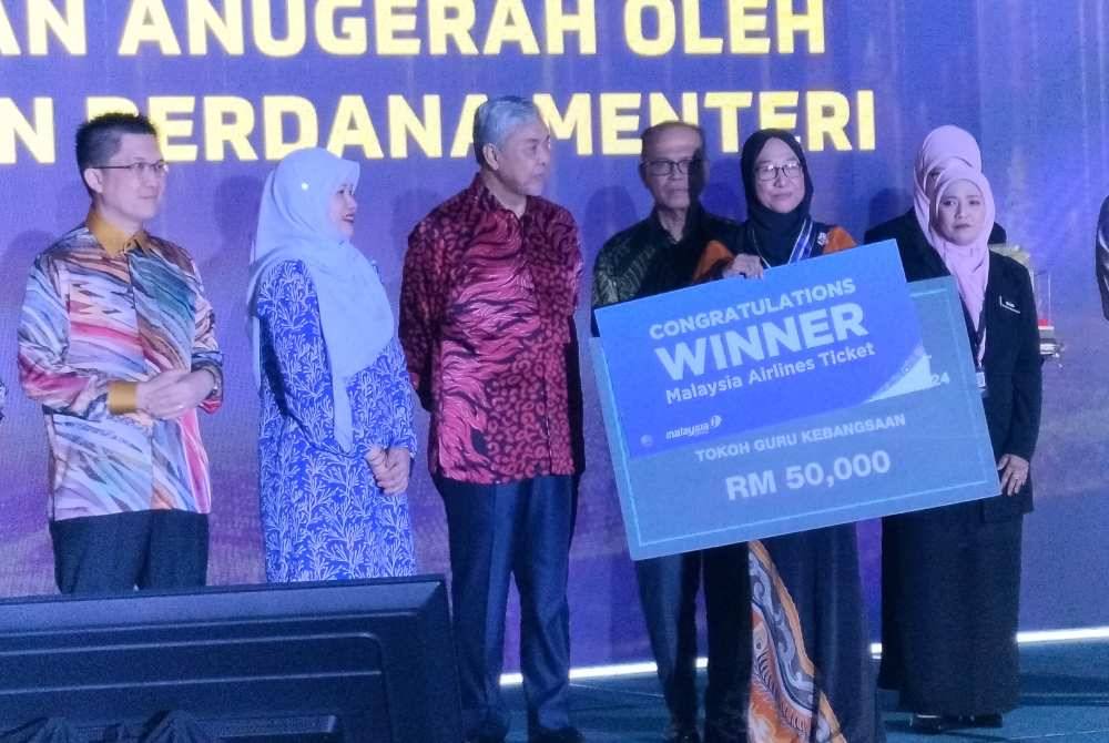 Ahmad Zahid (tiga dari kiri) bersama penerima Anugerah Tokoh Guru Kebangsaan 2024, Masariah Mispari sempena Sambutan Hari Guru Peringkat Kebangsaan kali ke-53 di Dewan Pusat Konvensyen Sultan Ahmad Shah (SASICC) pada Khamis.