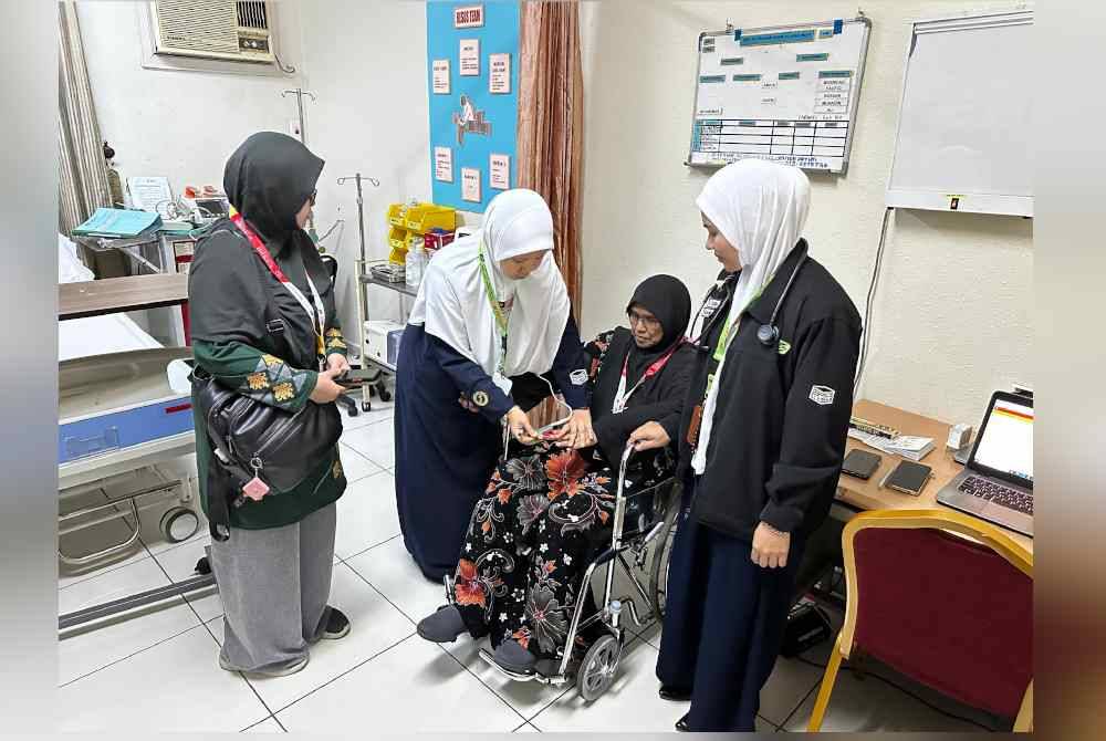 Petugas perubatan sedang merawat pesakit, Saadiah Abdullah, 65 tahun (dua, kanan) di Klinik Kecemasan Al-Janadriyah.