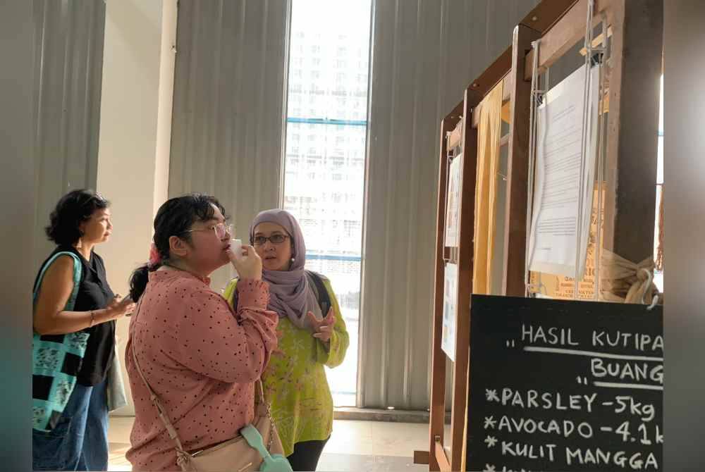 Pengunjung Pameran Seni Kuala Lumpur Colour District (KLCD) 2024 melihat contoh warna dihasilkan.