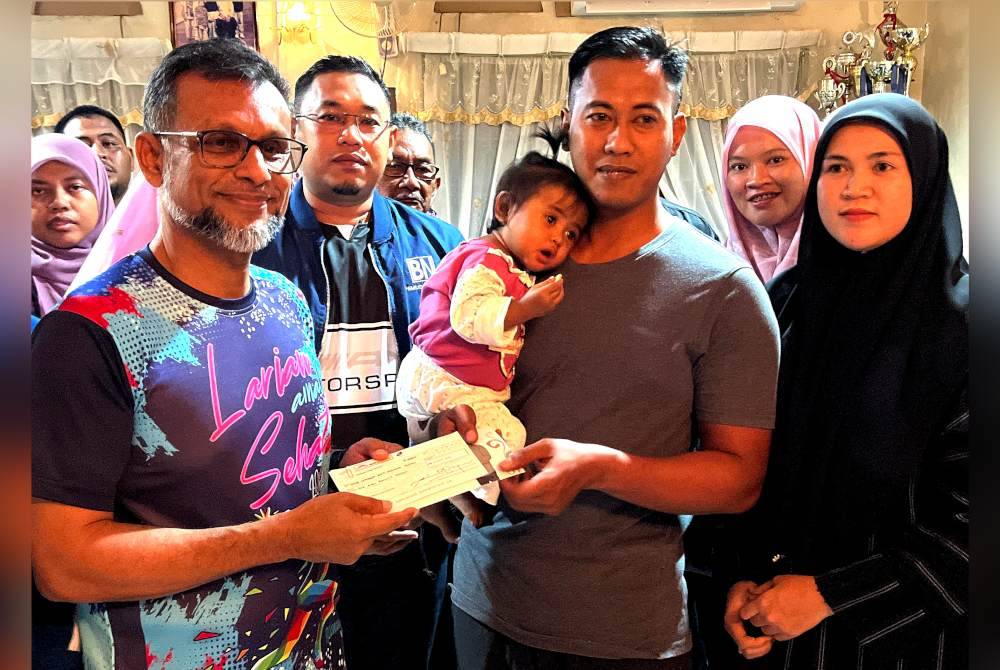 Mustapha (kiri) menyampaikan sumbangan kepadaMohamad Assahid.