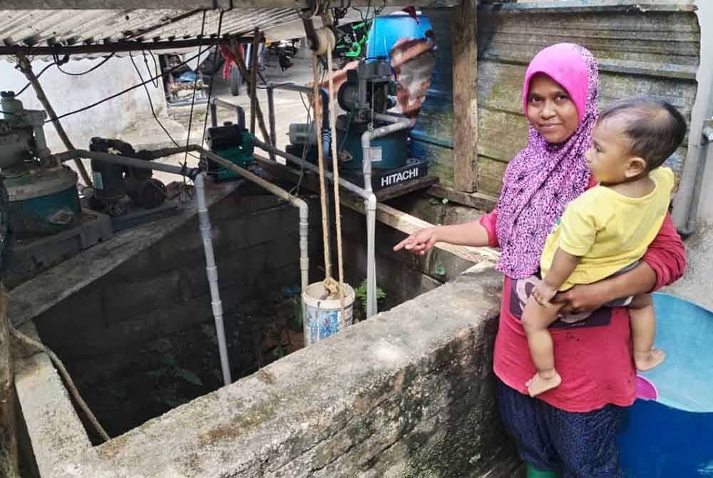 Che Norasmariza menunjukkan air perigi yang telah kering akibat musim panas dan kering yang melanda buat masa ini.