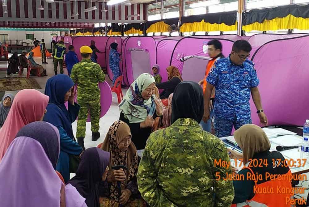 Beberapa agensi membantu mangsa banjir yang ditempatkan di PPS dalam daerah Kuala Kangsar. Foto: ihsan APM