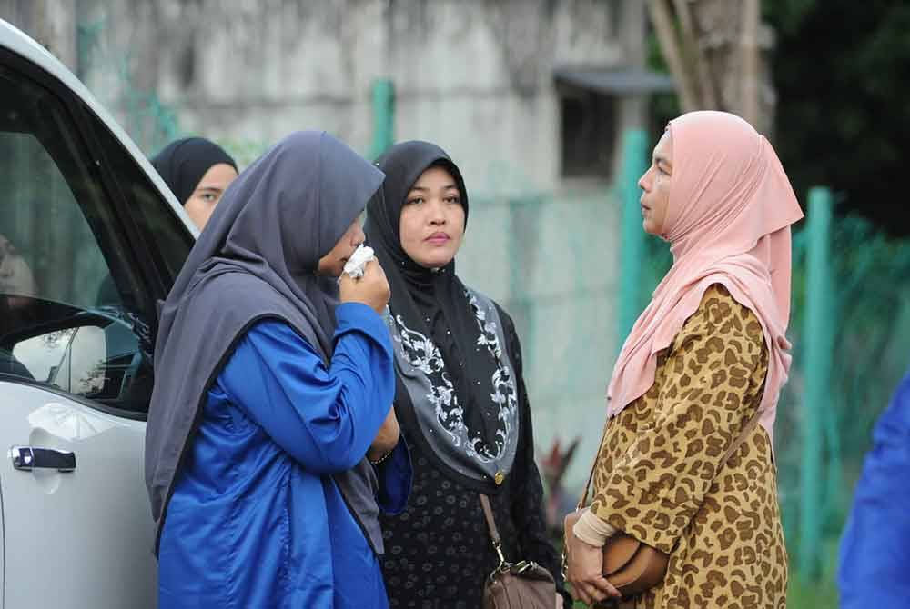 Ibu kepada anggota polis Allahyarham Ahmad Azza Fahmi, Nurhaliza Awaludin (kiri) menangis ketika tiba di Jabatan Forensik HSI, Johor Bahru, pada lewat petang, Jumaat.