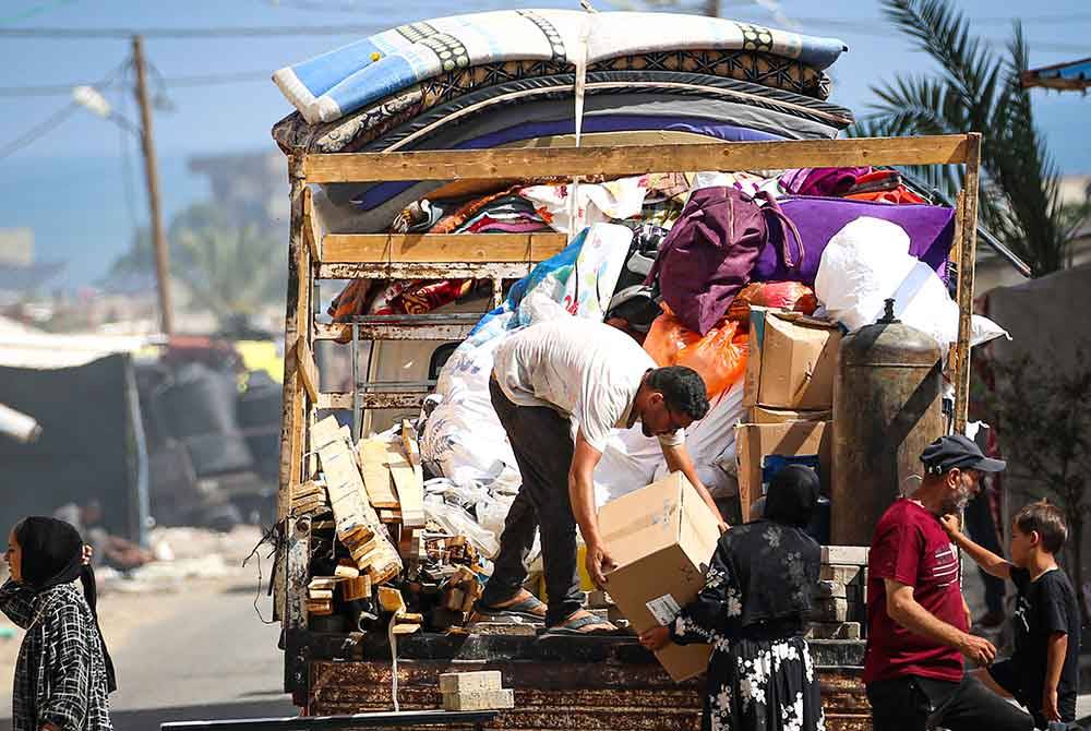 Sebuah keluarga menggunakan lori untuk memuatkan barangan mereka untuk melarikan diri berpindah keluar dari Rafah. - AFP