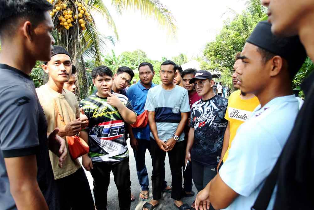 Syafiq Aiman Ab Halim (dua dari kiri), sahabat Allahyarham Konstabel Ahmad Azza Fahmi Azhar, bersama rakan yang lain susulan insiden serangan yang menimpa arwah di kediamannya di Jalan Kampung Poh Tambahan 1, Kampung Poh Bidor, pada Sabtu. Foto Bernama