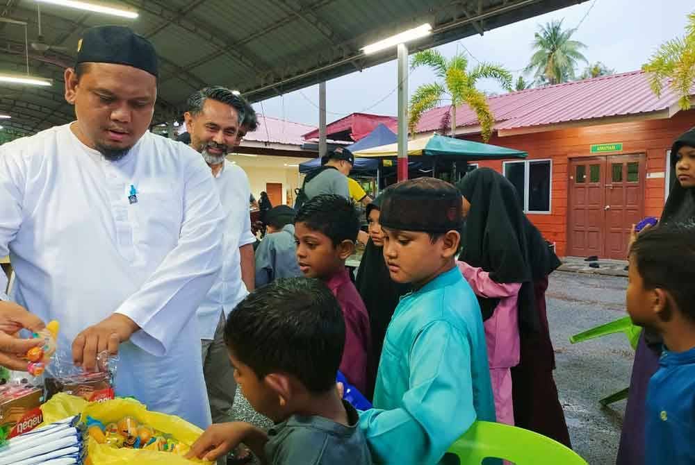 Muhammad Hamzah (kiri) bersama Norali menyantuni penghuni di Rumah Pertubuhan Badan Kebajikan Anak-anak Yatim Darussalam, Kampung Melayu Sungai Rapat.