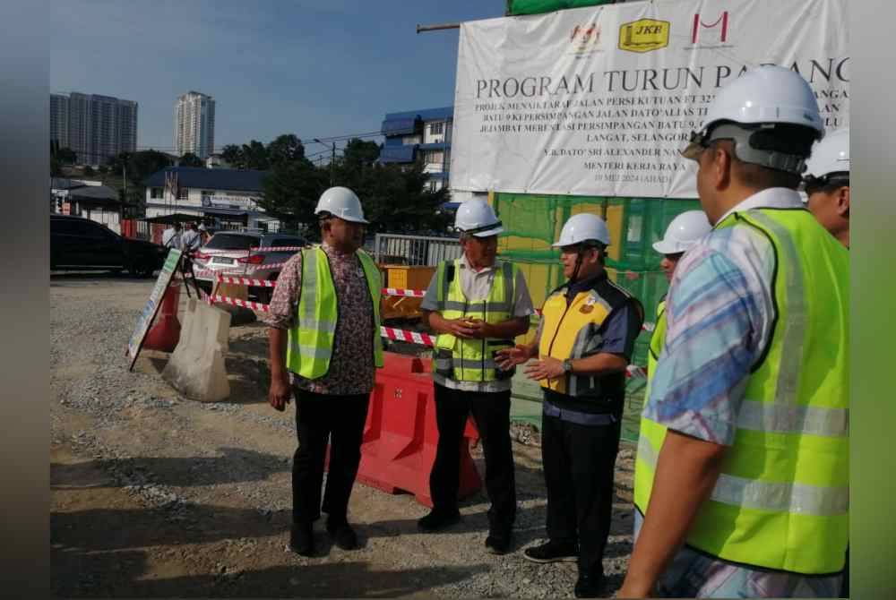 Mohd Sany (kiri) pada program turun padang Menteri Kerja Raya di Jalan FT3210 pada Ahad.