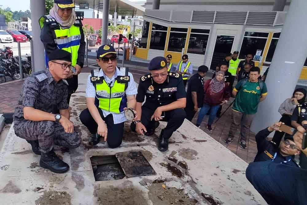 Aedy Fadly (dua kiri) menunjukkan tangki tambahan yang diubah suai pada sebuah treler dari negara jiran yang ditahan dan boleh mengisi sehingga 5,000 liter diesel.