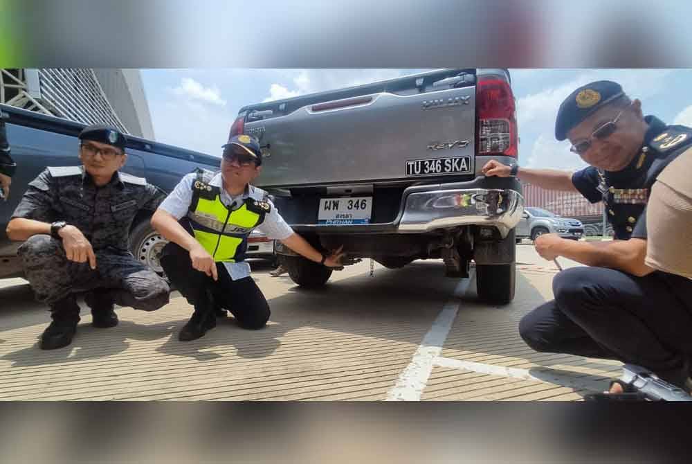 Aedy Fadly (tengah) menunjukkan sebuah pikap yang turut dipasang tangki tambahan di bawah kenderaan itu.