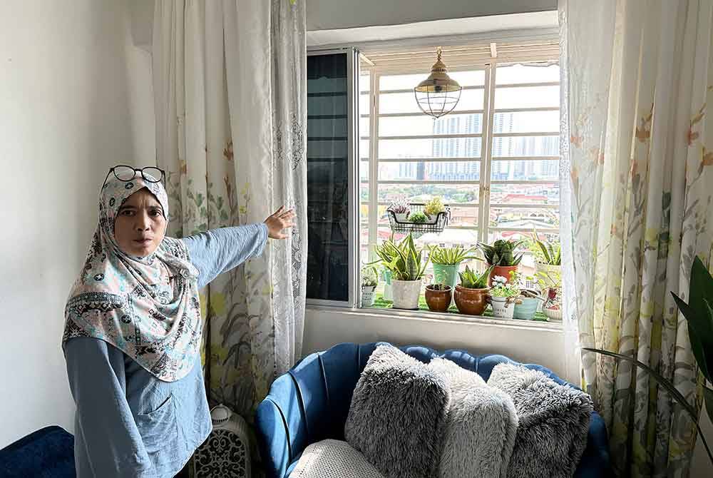 Nor Shamsiah menunjukkan tanaman pokok kecil di balkoni kecil di kediamannya yang terletak di tingkat 7. Foto Bernama