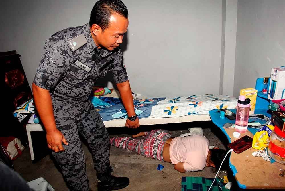 Seorang wanita warga Indonesia bersembunyi di bawah katil selepas terkejut melihat kehadiran anggota penguatkuasa dalam Op Bersepadu di Rumah Pangsa Panorama Lapangan Perdana, awal pagi Isnin. Foto Bernama