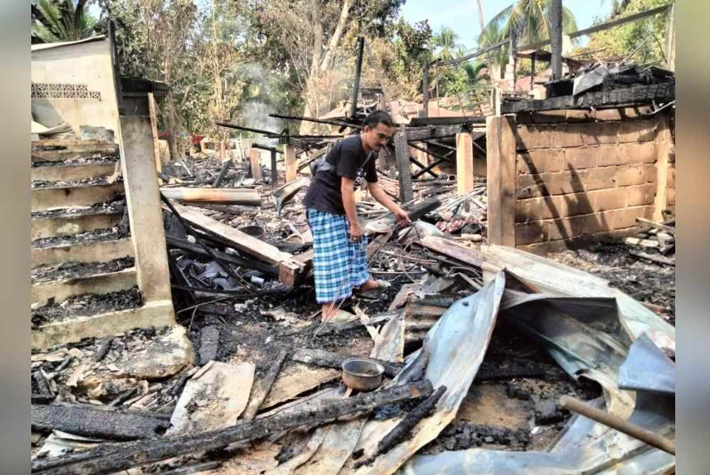 Mohd Azizi menunjukkan barang yang hangus dalam kejadian kebakaran malam Ahad.