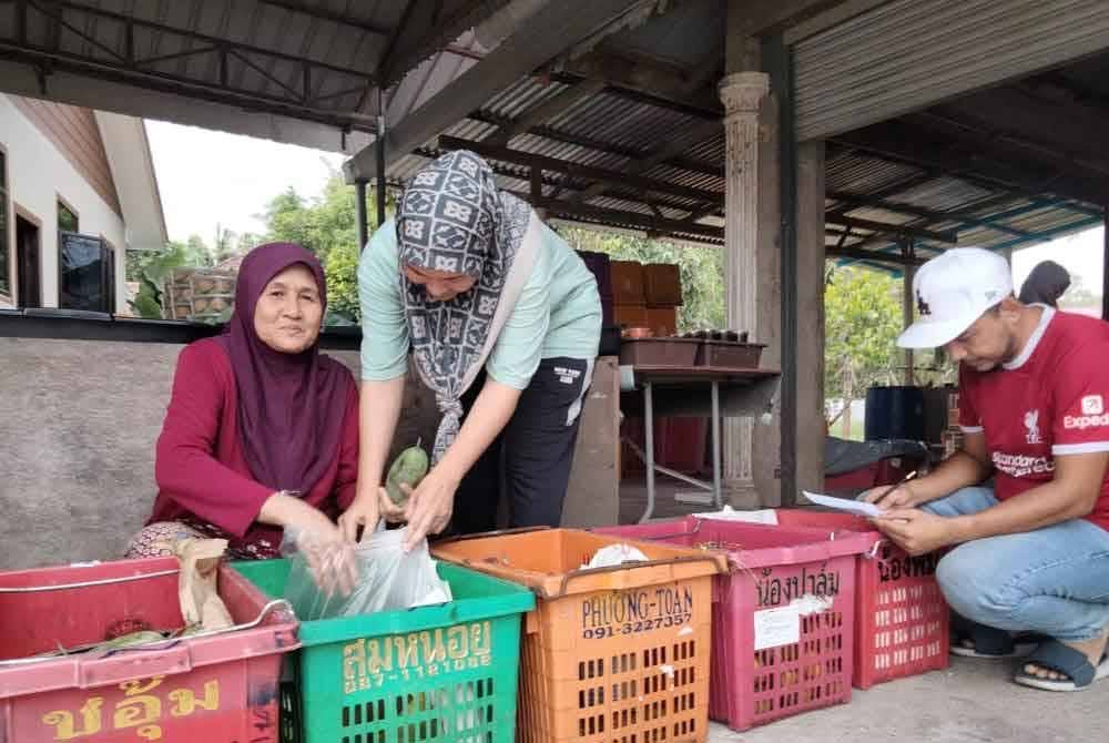 Asmah dibantu anak dan menantu menguruskan pasar mini.