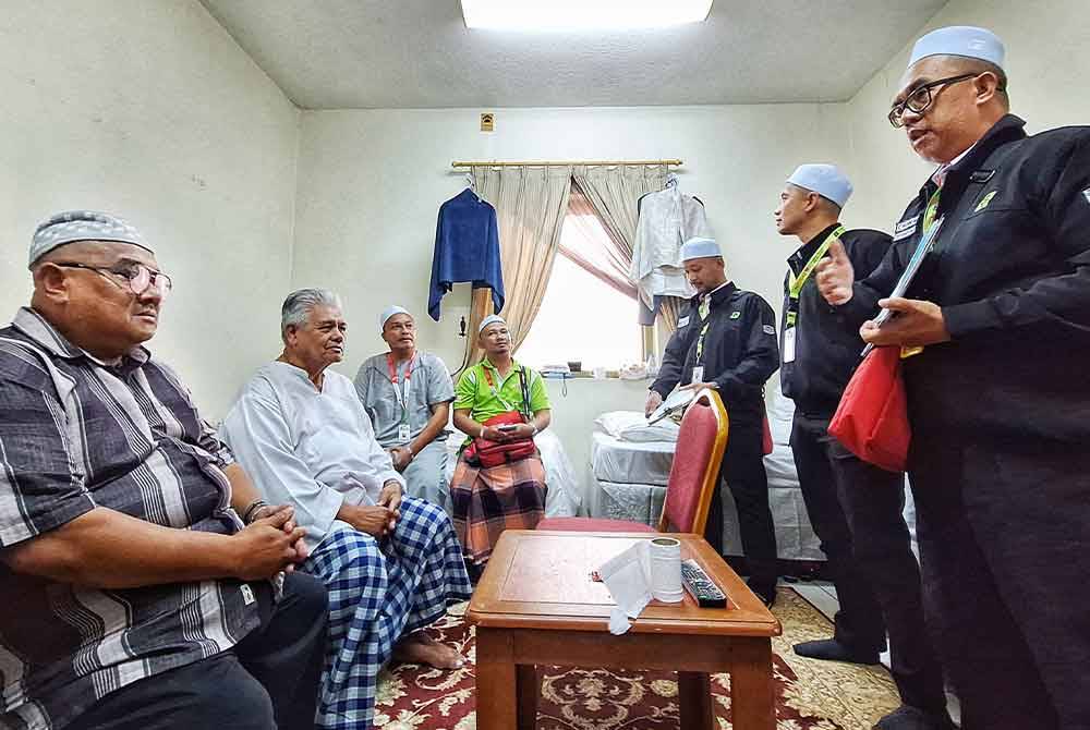Pasukan perubatan sedang menemui jemaah haji lelaki bagi bertanyakan tahap kesihatan mereka.