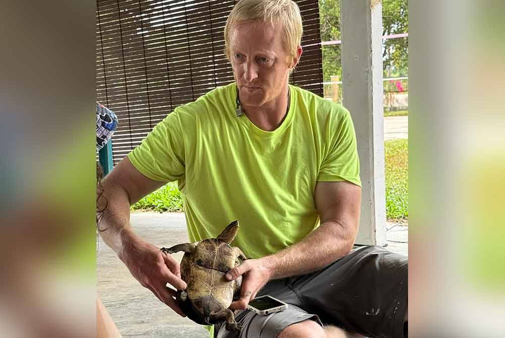 Gaillard memegang kura-kura.