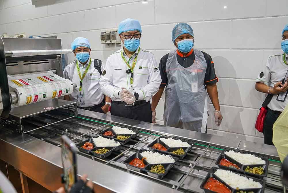 Syed Saleh (dua, kiri) meninjau proses penyediaan sajian makanan jemaah haji Malaysia oleh Al Wafa Catering.