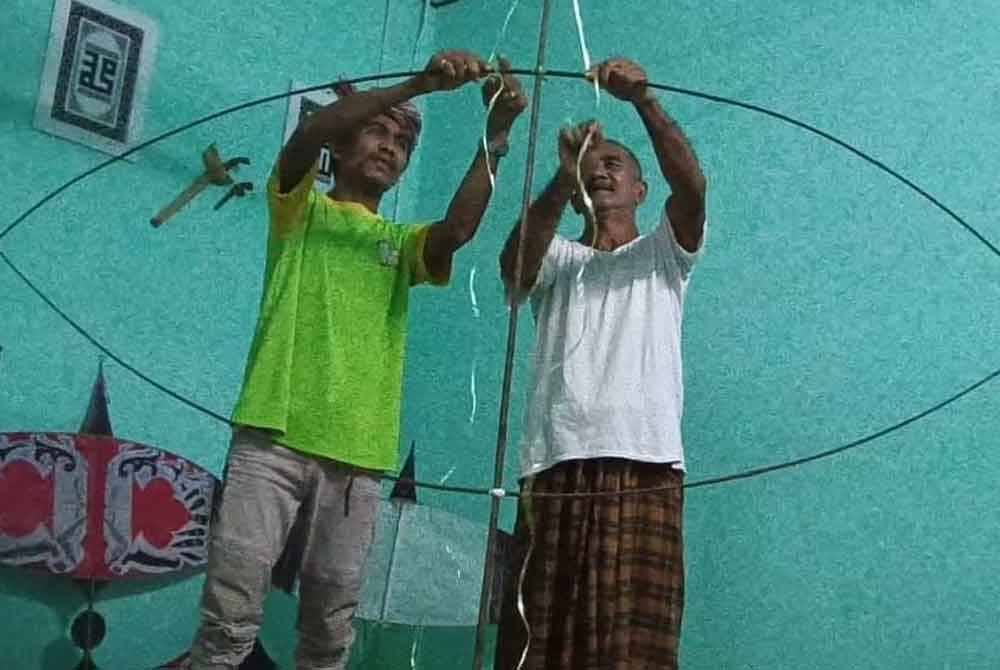 Che Mat (kiri) cukup teliti dalam penjagaan rangka wau milik arwah bapanya.