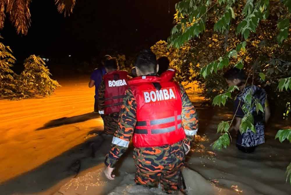 Pasukan bomba membantu memindahkan mangsa yang terjejas banjir di Parit. Foto ihsan Bomba Perak
