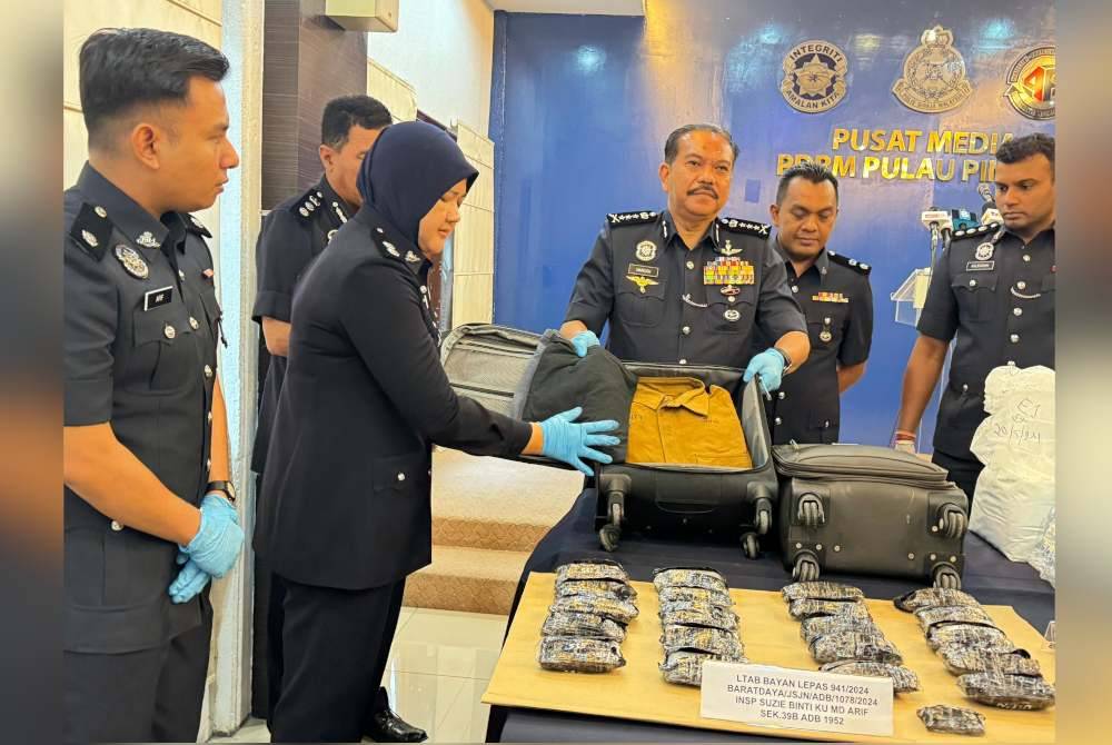 Hamzah (tengah) menunjukkan bagasi dibawa suspek yang mengandungi dadah di LTAPP pada 20 Mei lalu