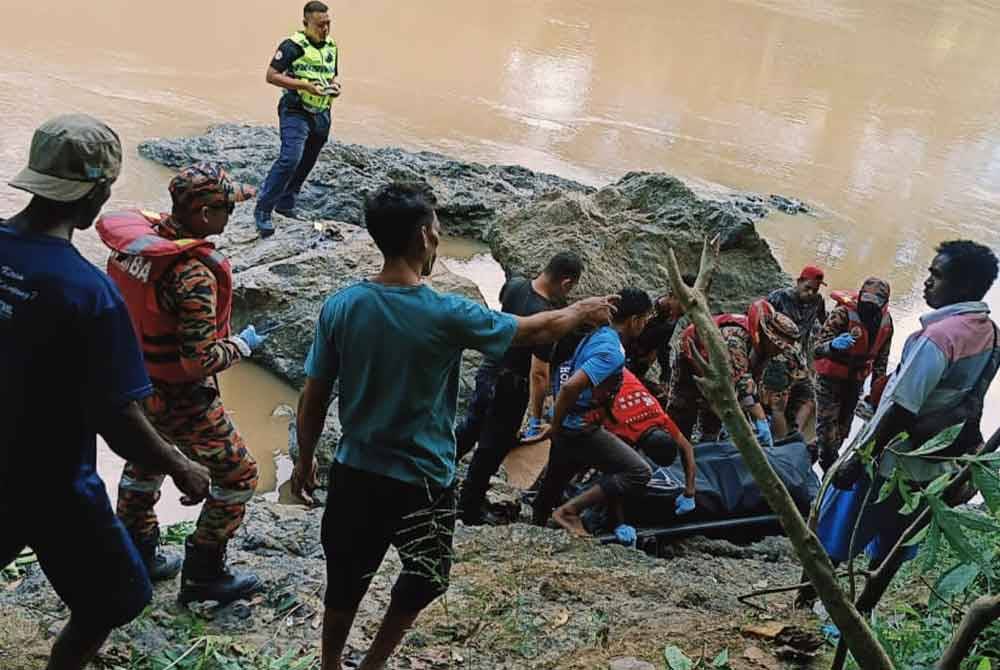 Anggota bomba dan orang ramai membantu mengangkat mayat mangsa yang lemas di Sungai Ulu Segama, Kinabatangan.