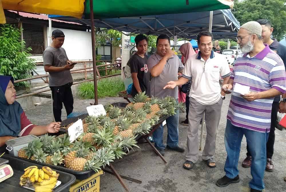 Syed Abu Hussin (kanan) bertemu peniaga ketika meninjau Pasar Pagi Taman Kaya di Taiping pada Khamis.