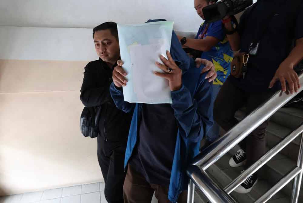 Tertuduh menutup wajahnya ketibaan berada di Mahkamah pada Khamis.