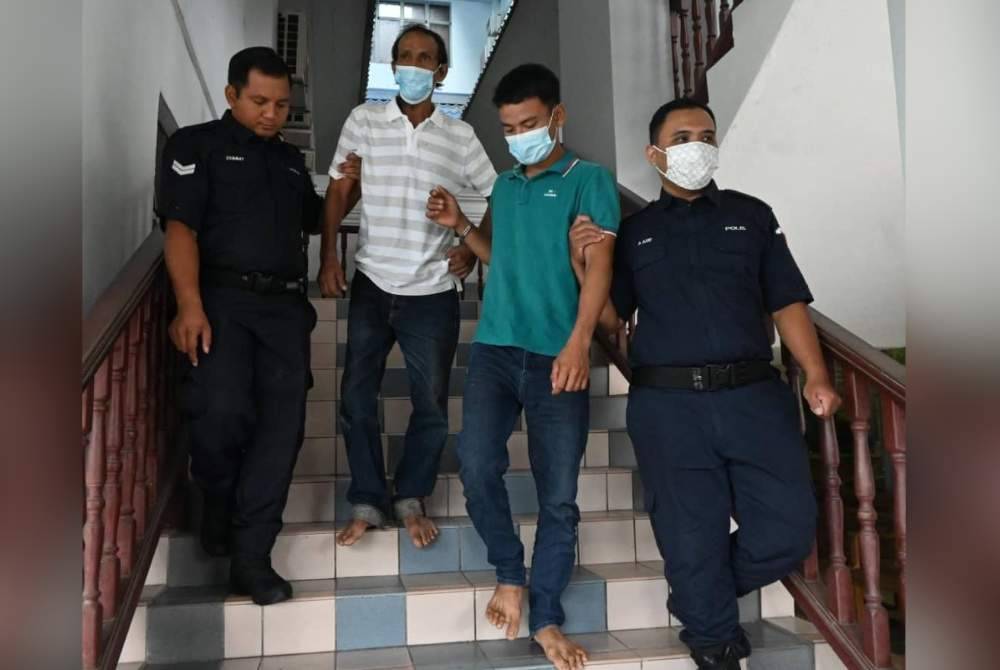 Kedua-dua tertuduh ketika dibawa oleh polis pengiring keluar dari Mahkamah Majistret di Melaka pada Khamis.