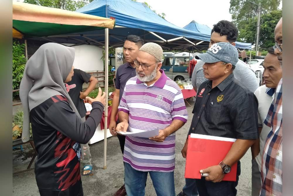 Syed Abu Hussin (dua dari kiri) bertemu peniaga ketika meninjau Pasar Pagi Taman Kaya pada Khamis.