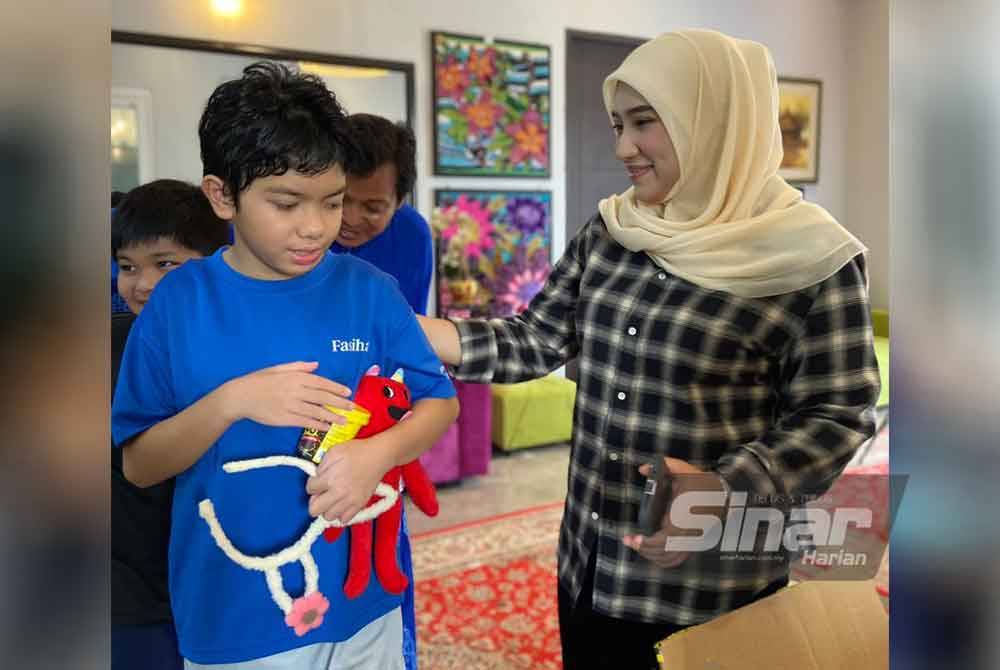 Kanak-kanak autisme dan sindrom down gembira menerima cenderamata.