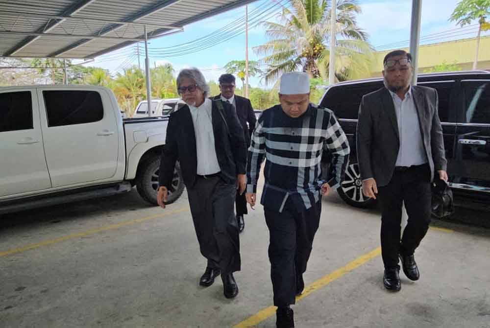 Ebit Lew (tengah) diiringi peguamnya, Ram (kiri) ketika tiba di Mahkamah Majistret Tenom.