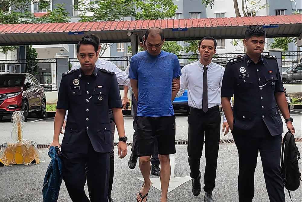 Yau Hon Choong (dua dari kiri) diiring polis ketika hadir ke mahkamah.