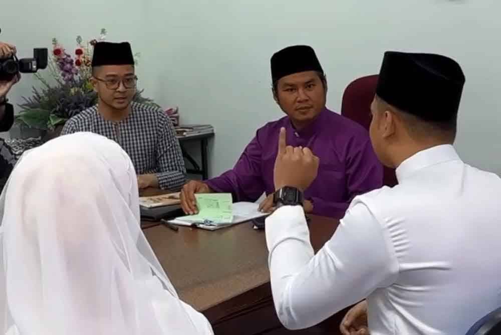 Aqif Ikhwan menggunakan bahasa isyarat sebagai ganti lafaz akad nikah yang diterjemahkan Mohamad Nazrul (dua kiri) dalam satu majlis di Pejabat Agama Daerah Seremban pada Jumaat.