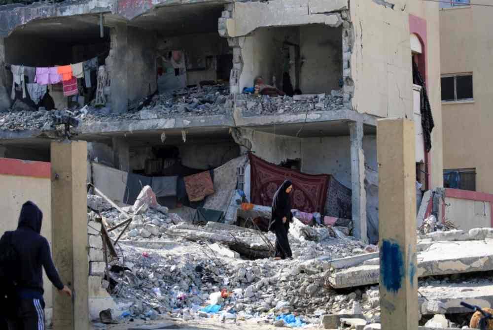 Penduduk Gaza yang hilang tempat tinggal sanggup mengambil risiko berlindung di bangunan separa musnah akibat dibedil Israel. Foto AFP