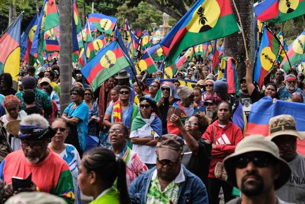 
Peserta protes mengibarkan bendera Barisan Pembebasan Kebangsaan Sosialis Kanak (FLNKS) ketika membantah pembaharuan hak mengundi kepada golongan bukan peribumi yang diluluskan Parlimen Perancis.