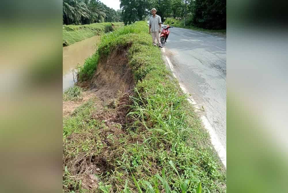 Penduduk melihat keadaan Jalan utama di Kampung Bentong, Kluang yang terhakis selepas tebing Sungai Melantai terhakis dan runtuh pada 15 Mei lalu.