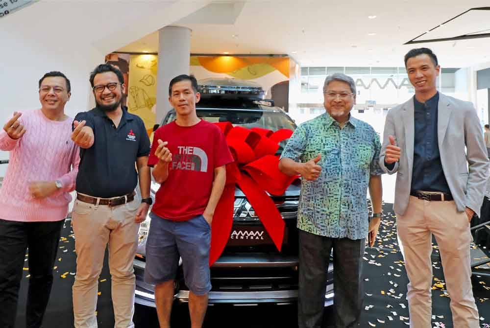 Eng Koon (tengah) bergambar bersama hadiah utama Mitsubishi Xpander disaksikan Ken Chin (kiri) dan Mohd Yusri (dua dari kanan) selepas majlis pengumuman di Aman Central.