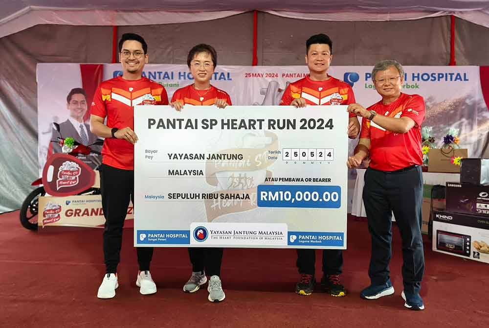 Replika cek dana diserahkan Mohammed Taufiq (kiri) kepada Setiausaha Kehormat Yayasan Jantung Malaysia, Adam Tan (dua dari kanan) sambil disaksikan Bee Chan (dua dari kiri).