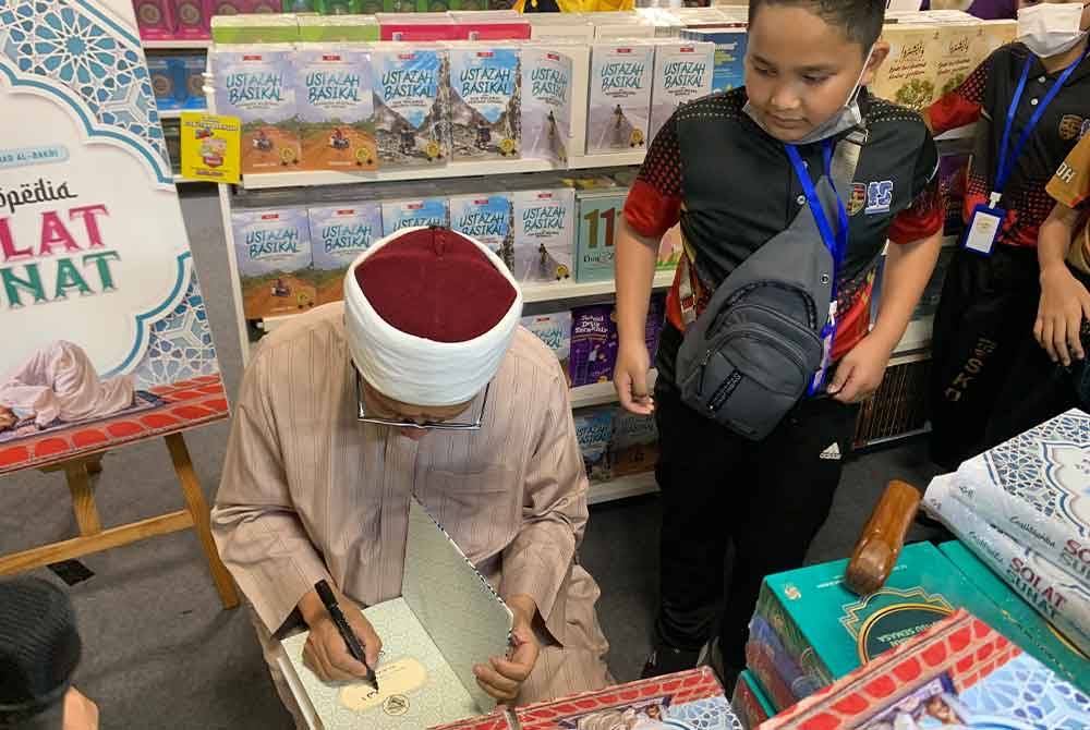 Zulkifli menandatangani buku yang dibeli pengunjung PBAKL 2024 pada Sabtu.