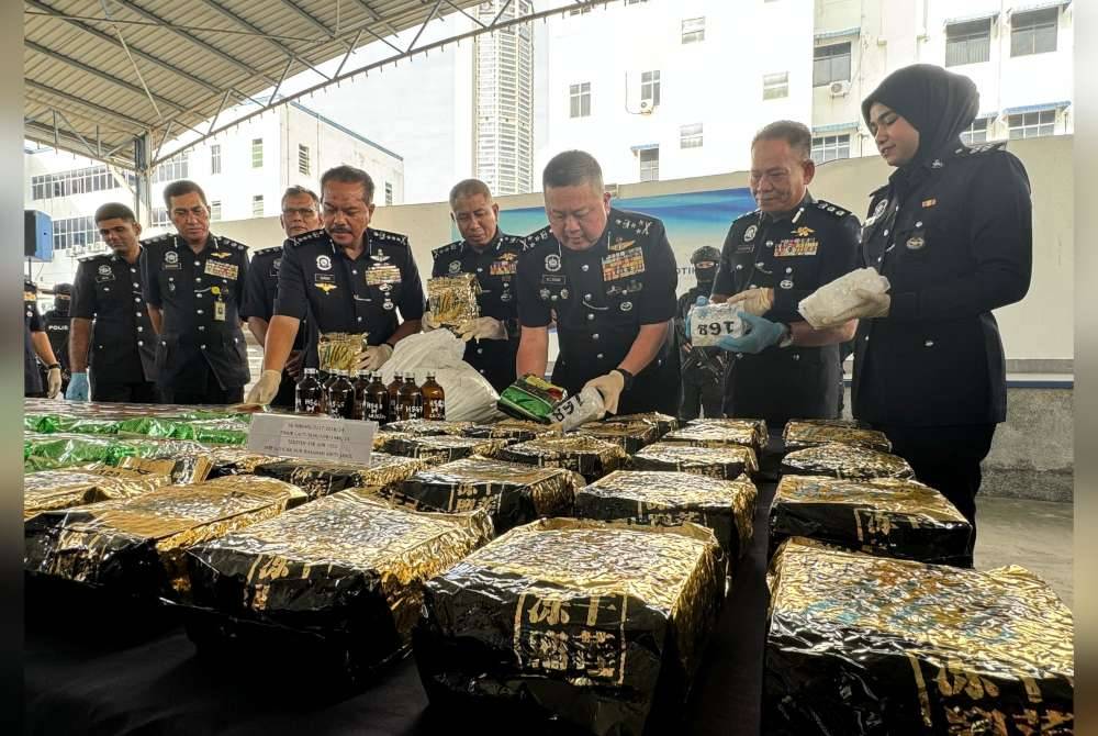 Kok Chin (tiga dari kanan) menunjukkan dadah yang dirampas dari suspek dalam dua serbuan.