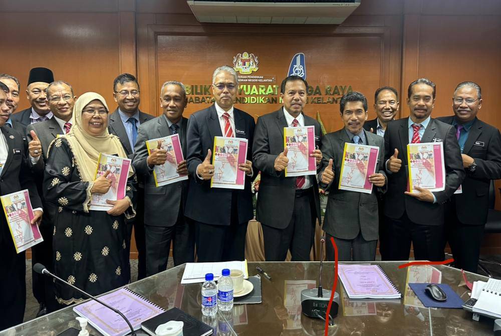 Mohamad (lima dari kanan) dan barisan pegawai kanan JPN menunjukkan laporan keputusan SPM Tahun 2023 negeri Kelantan pada Isnin.
