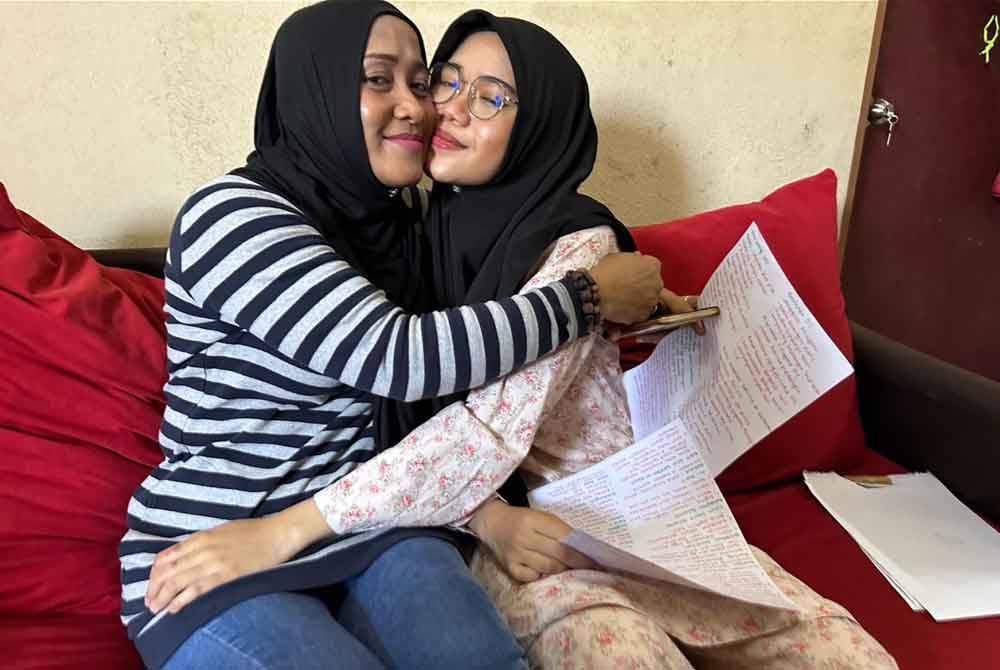 Siti Bayu (kanan) dipeluk ibunya, Che Zusila (kiri) melepas menerima keputusan cemerlang SPM pada Isnin