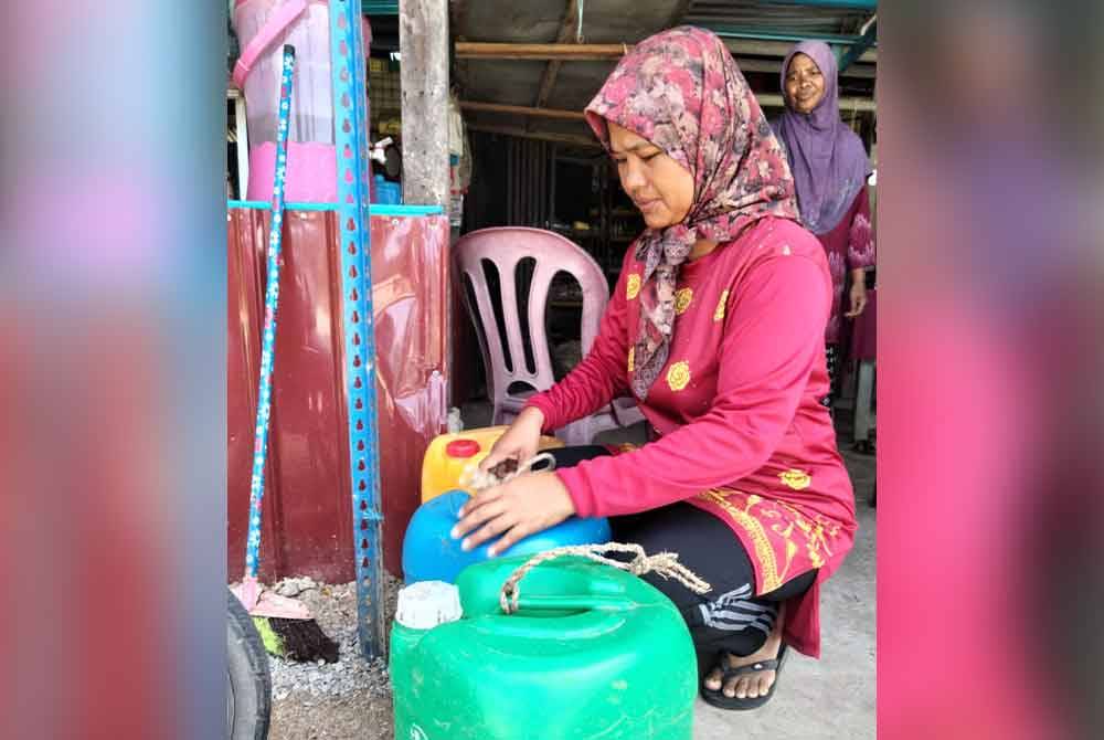 Noorhayati menunjukkan tong kosong yang disediakam untuk mengisi air