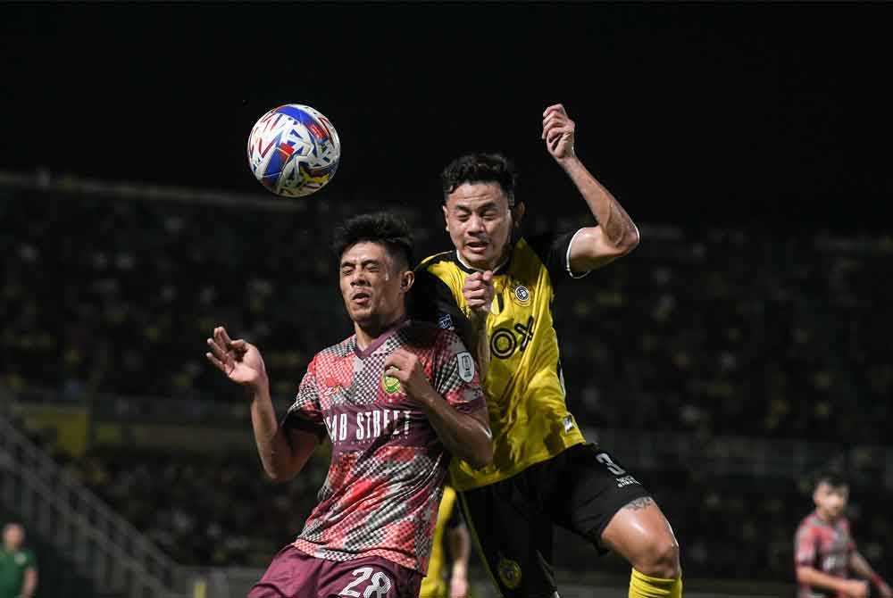 Pemain Kedah Darul Aman FC, Muhammad Syafiq Ahmad (kiri) diasak pemain pertahanan Perak FC, Tommy Mawat Anak Bada (kanan) pada saingan Liga Super Malaysia 2024 di Stadium Darul Aman Jumaat lalu.
