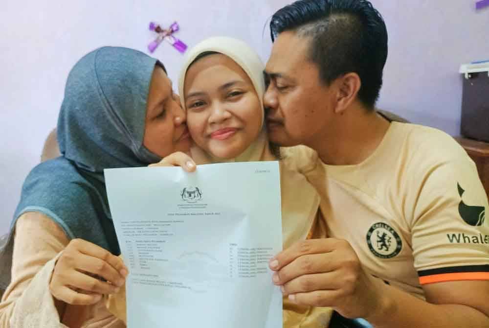 Fifi Nurfatin menerima ciuman kasih daripada ibu bapanya selepas memperoleh 9A dalam SPM 2023.
