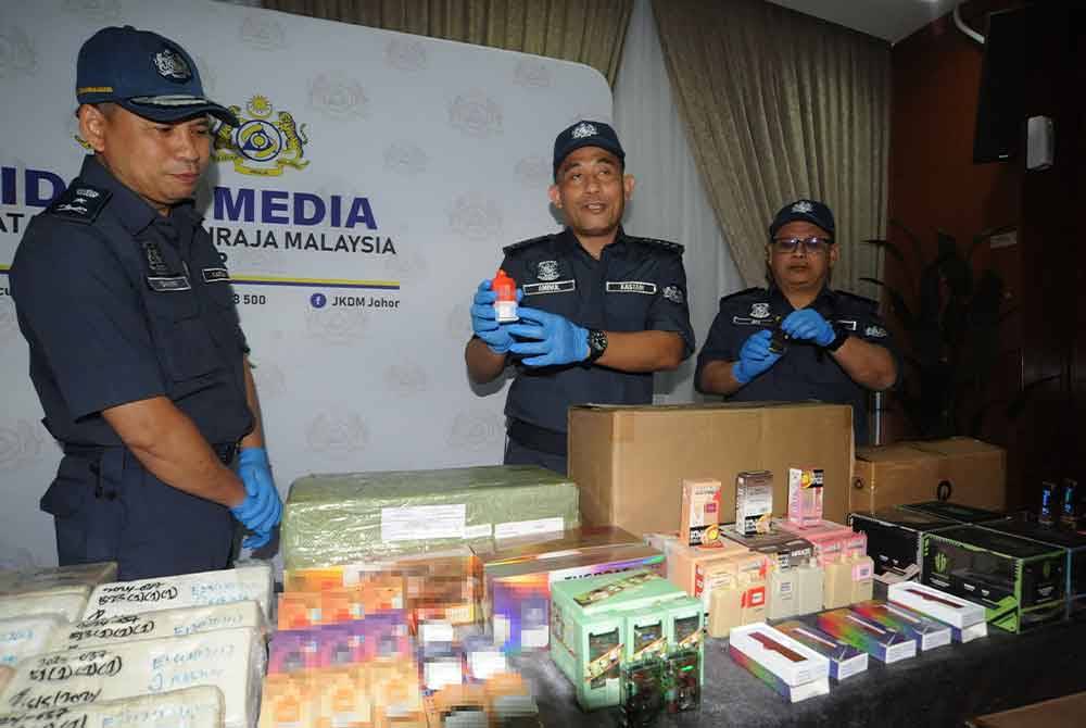 Aminul Izmeer (tengah) menunjukkan cecair rokok elektrik yang dirampas pada sidang media di Menara Kastam Johor, pada Isnin.