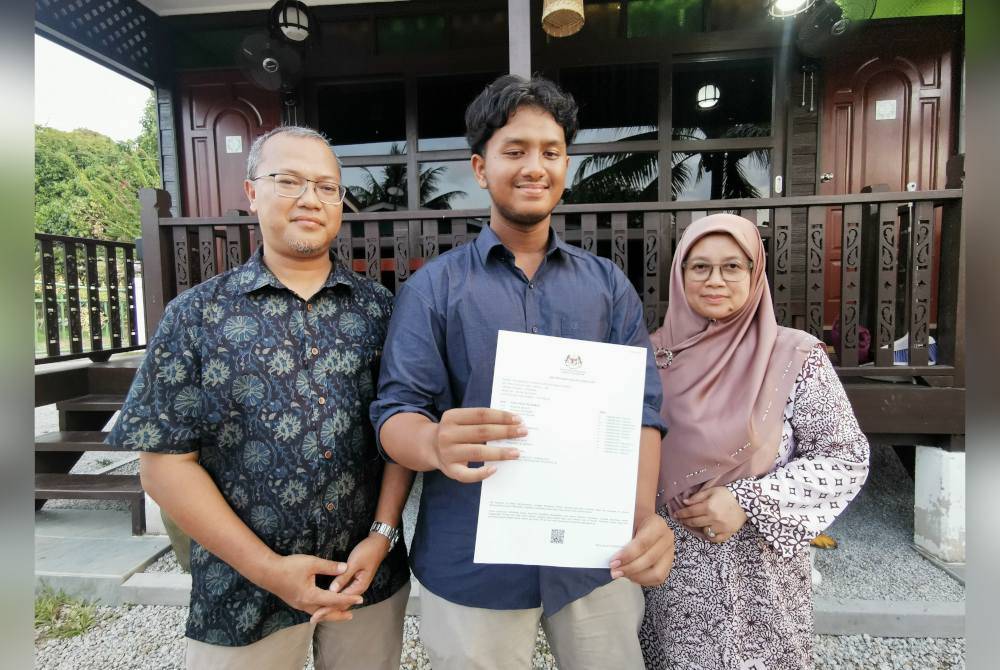 Muhammad Syamer di samping ibu dan bapanya menunjukkan keputusan SPM yang diperoleh.