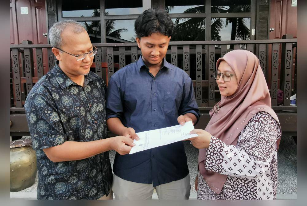 Muhammad Syamer (tengah) bersama ibu dan bapanya ketika ditemui Sinar Harian di Kampung Sekati, di Kuala Terengganu petang Isnin.
