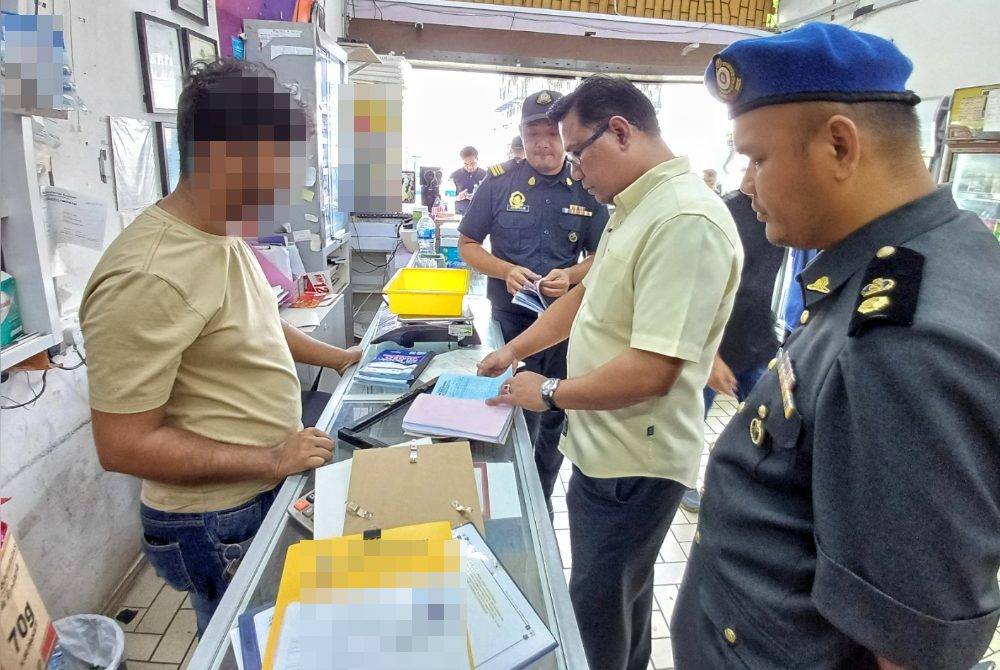 Pegawai KPDN sedang menyemak buku stok barangan kawalan dan menyalahgunakan minyak masak bersubsidi di salah sebuah premis perniagaan di Bandaraya Kuantan pada Selasa.