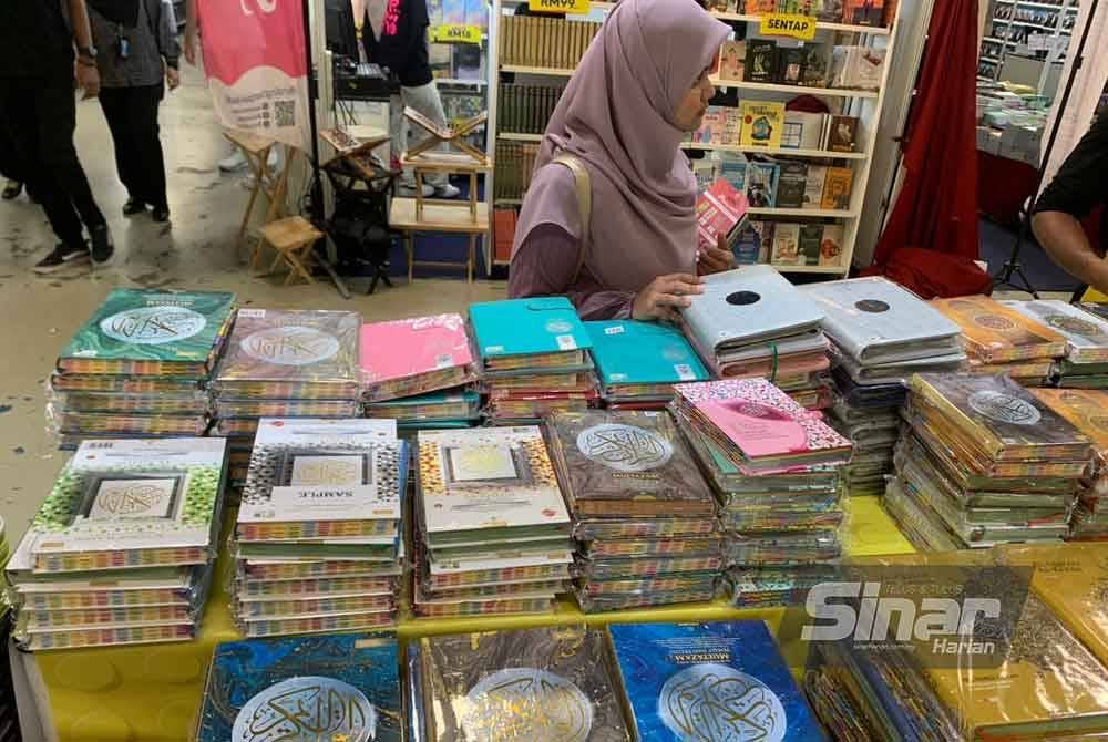 Pengunjung PBAKL 2024 di reruai Karangkraf melihat pelbagai jenis al-Quran.