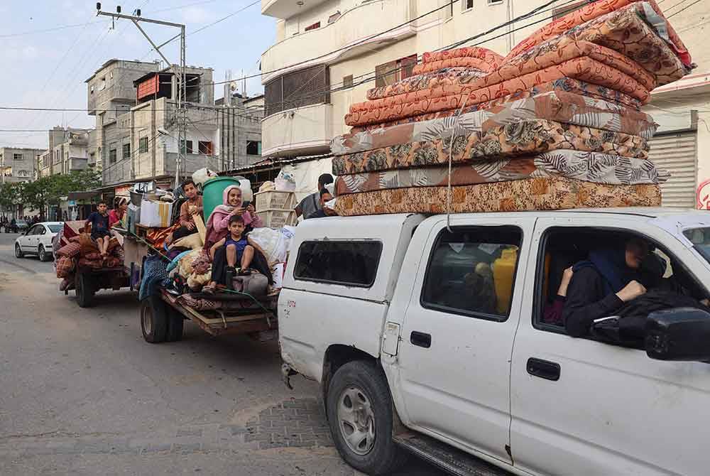 Rakyat Palestin melarikan diri dari kawasan Tal al-Sultan di Rafah dengan barang-barang mereka berikutan serangan baharu Israel di bandar di selatan Semenanjung Gaza pada Selasa. Foto AFP